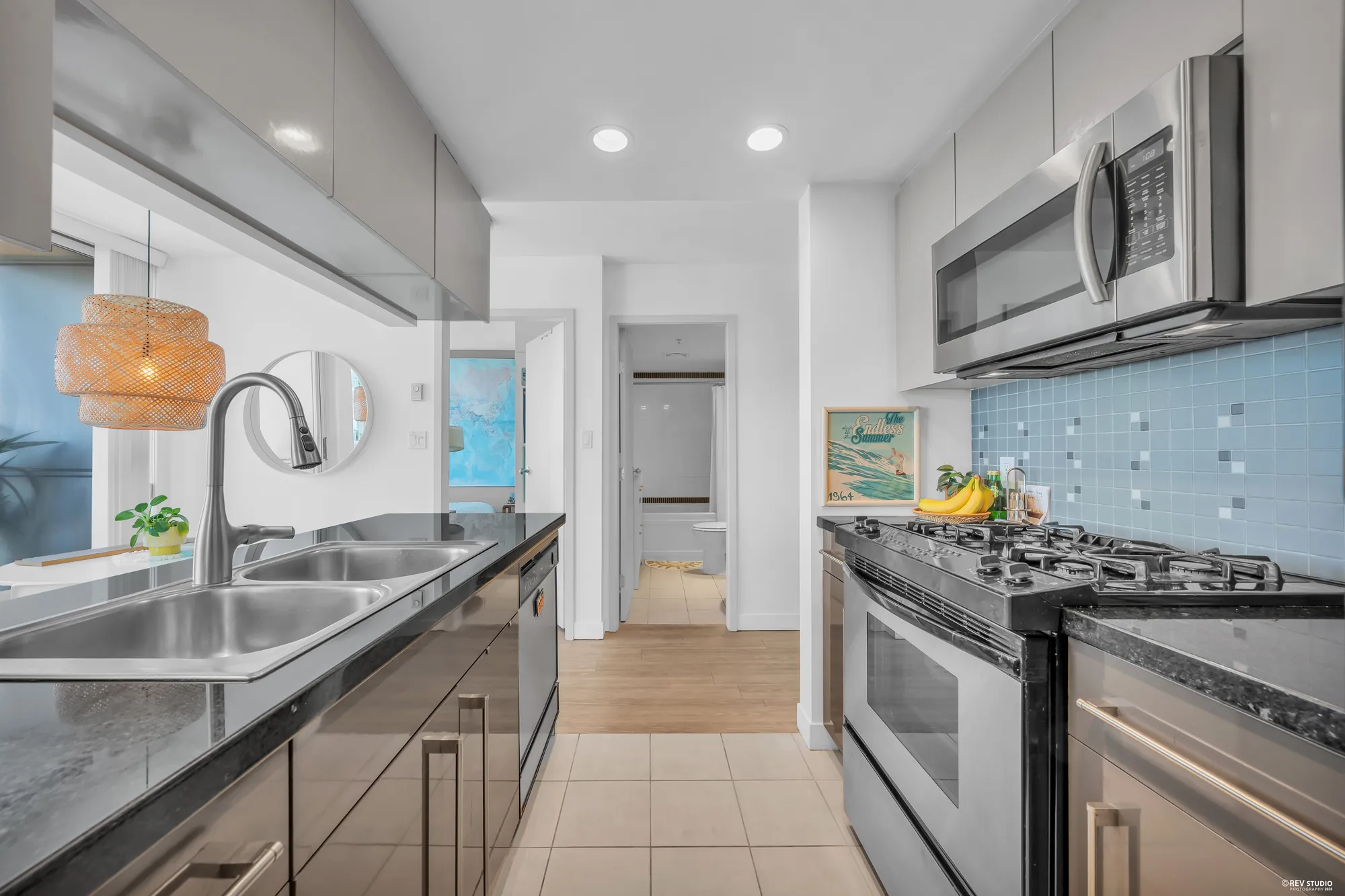 Down the galley: the sink and dishwasher, the range, the counters both sides, the hall to the bedroom