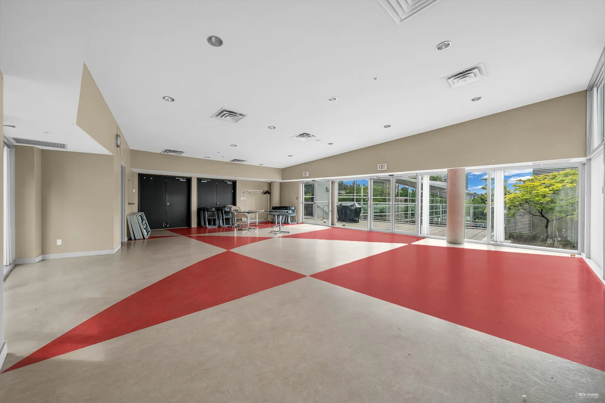 The party room: a long room with a red and cream floor, columns, and glass doors to the garden