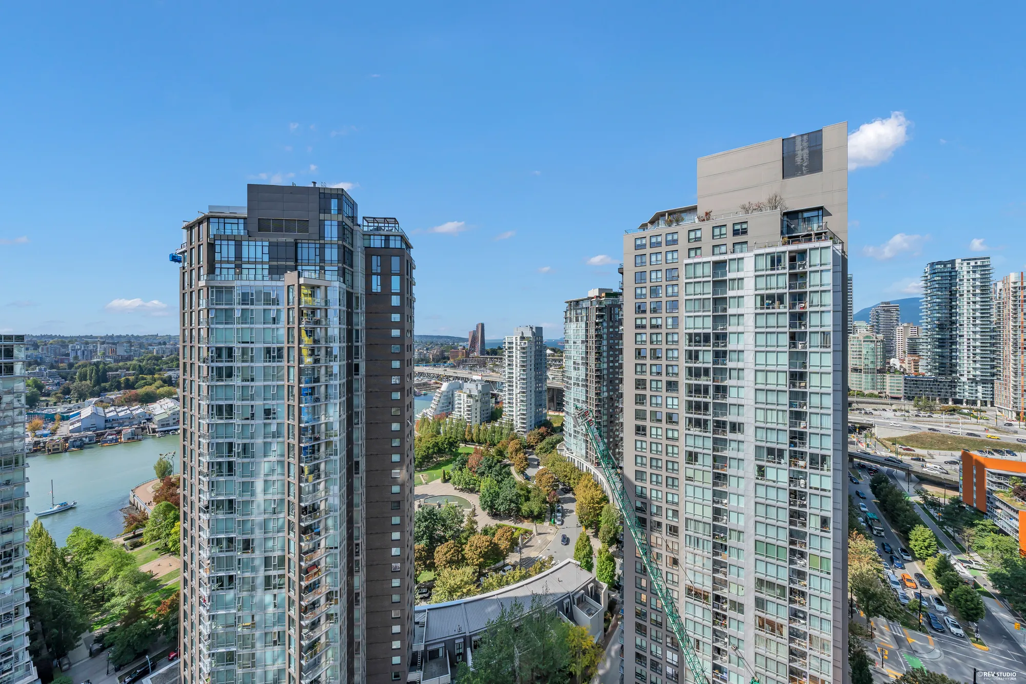 From the balcony: two towers close by, False Creek and the seawall below, boats on the water